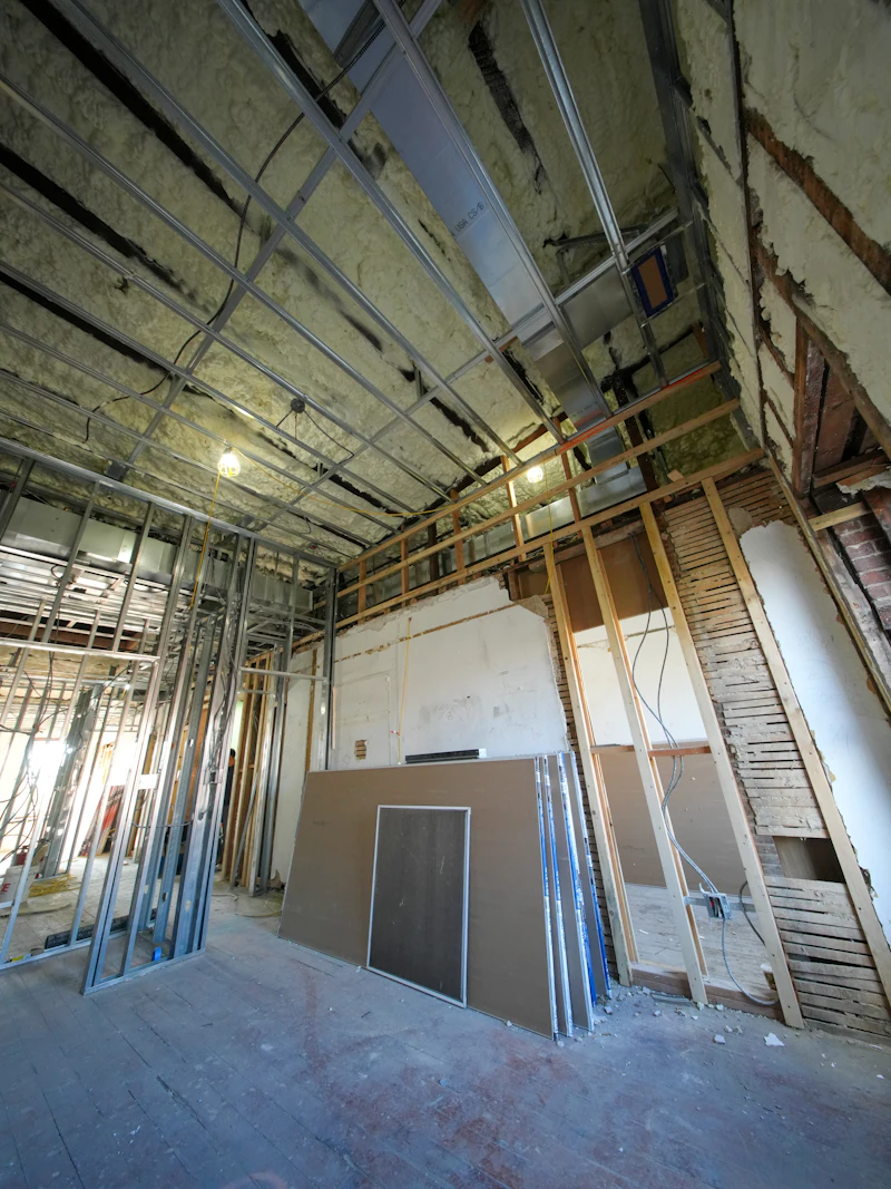 Metal stud framing with plasterboard sheets during a dry lining installation
